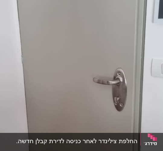 דלת מתכת עם ידית כסופה וחור מנעול